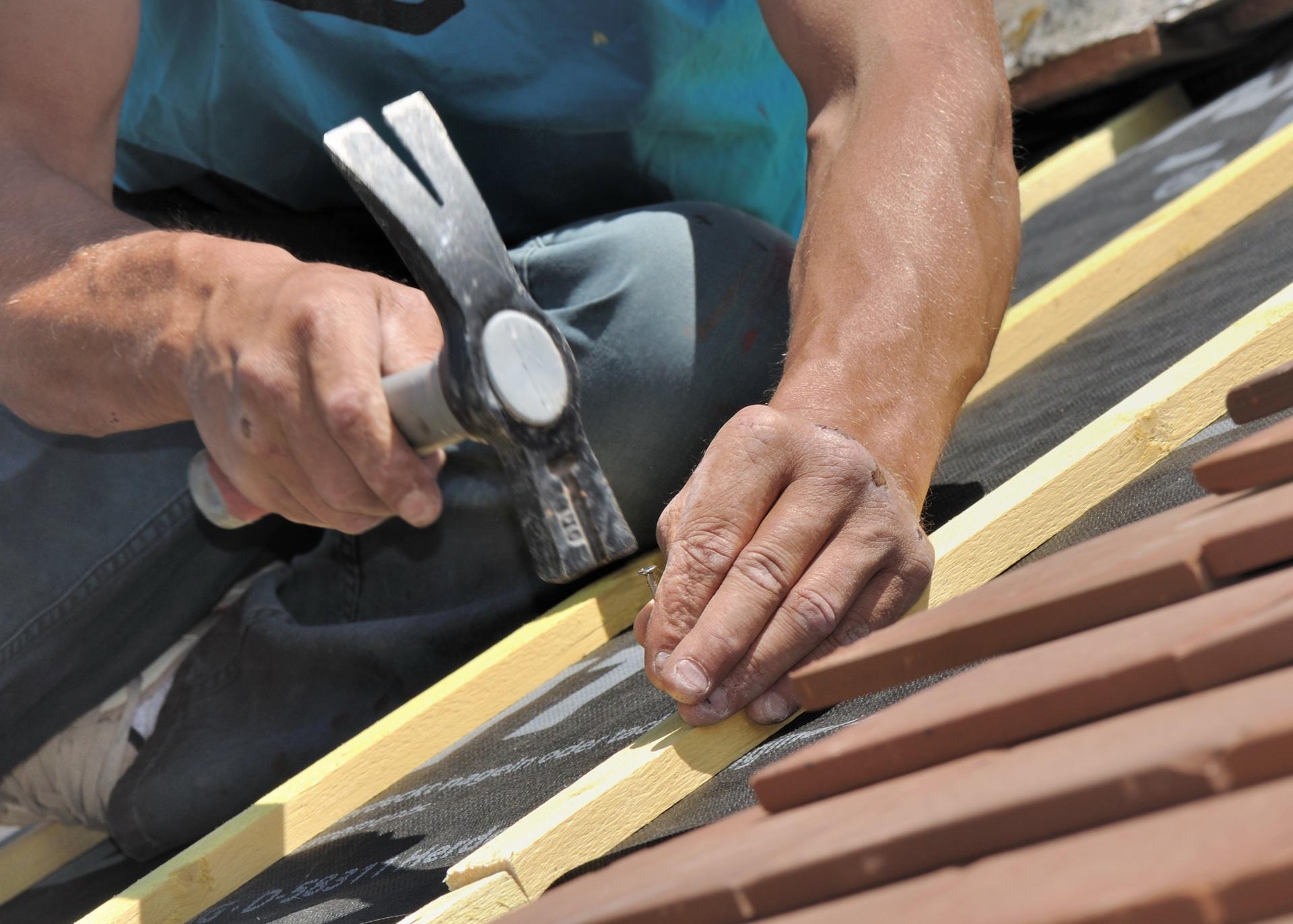 Handwerker fixiert Dachlatten | Dachsanierung

